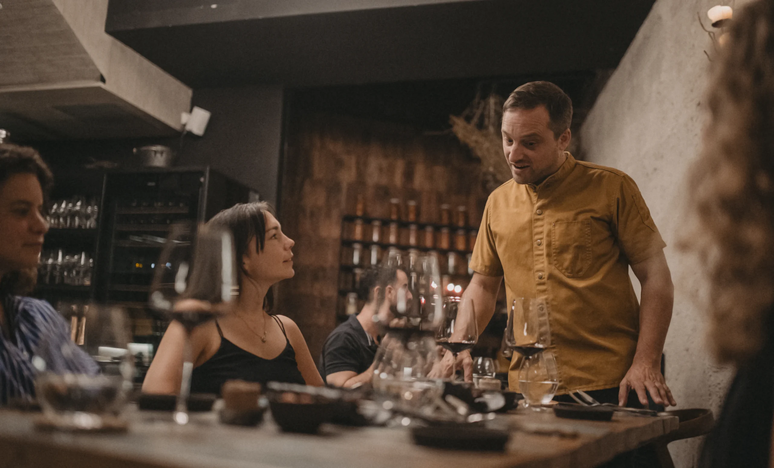 El chef de 99 Restaurante conversando con comensales en la mesa